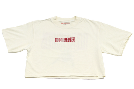 Beige crop top with 'FEED THE MEMBERS' text in red on a white background